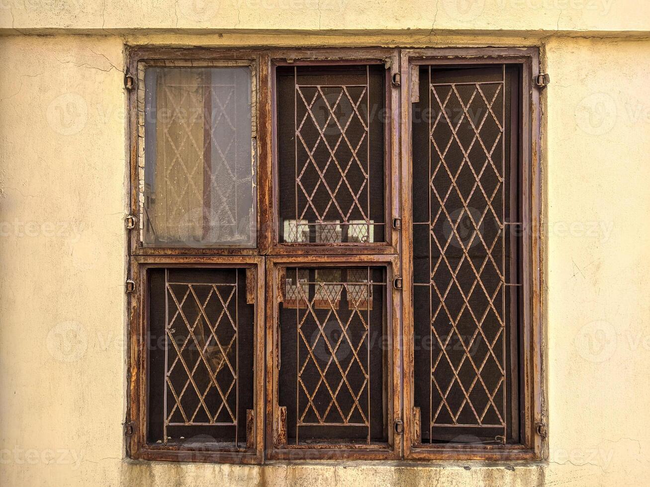 A window with bars on it and a brown door photo