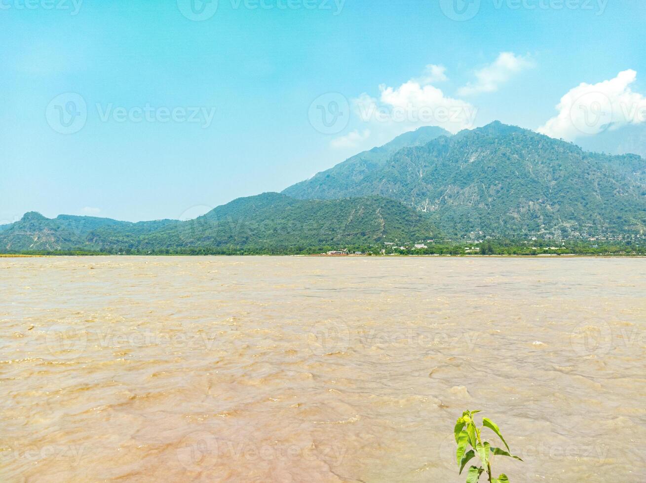 A boat is sitting in the water near a mountain photo
