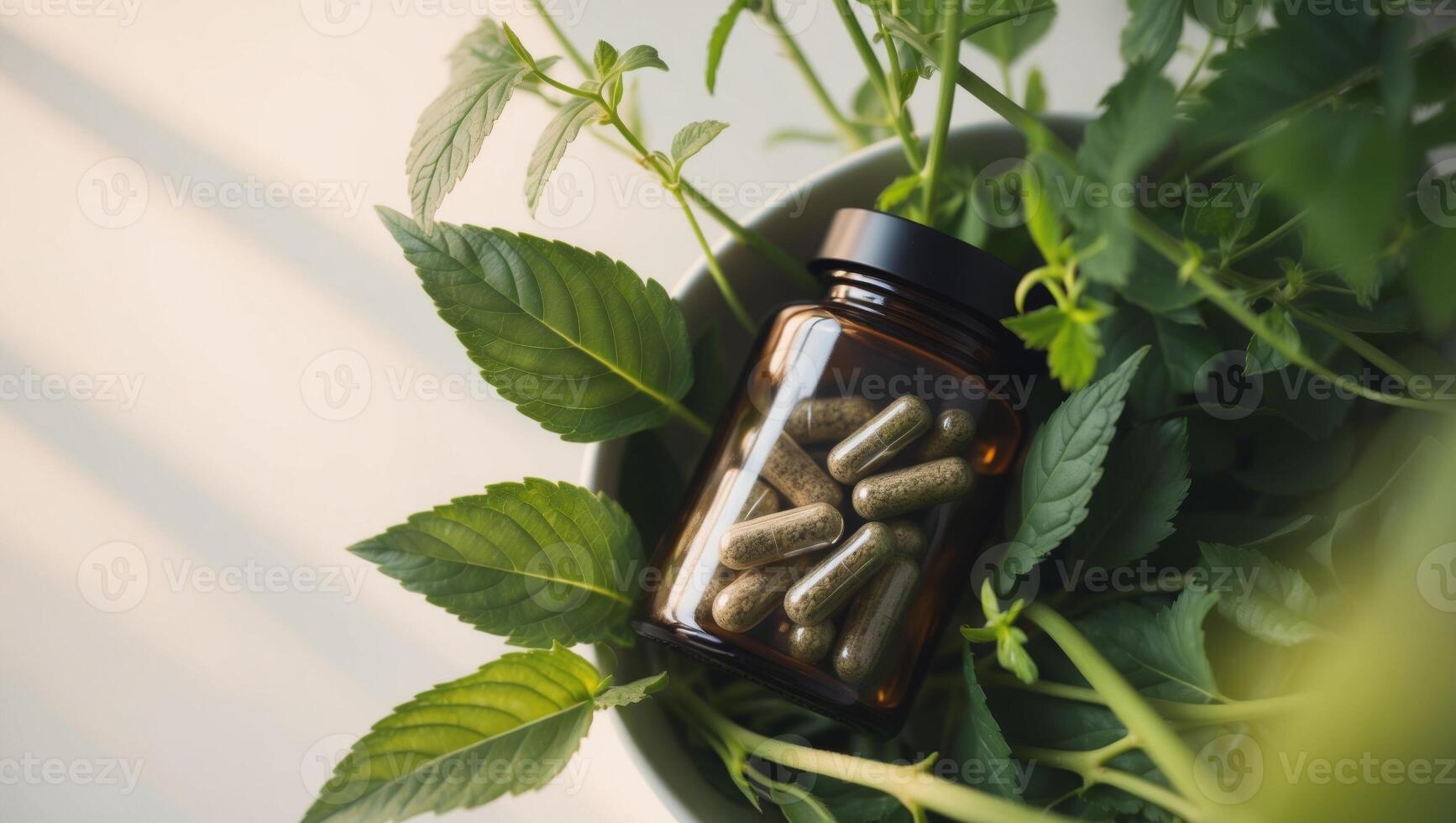A bottle of capsules is surrounded by green leaves photo