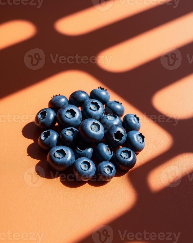 A pile of blueberries on an orange surface photo