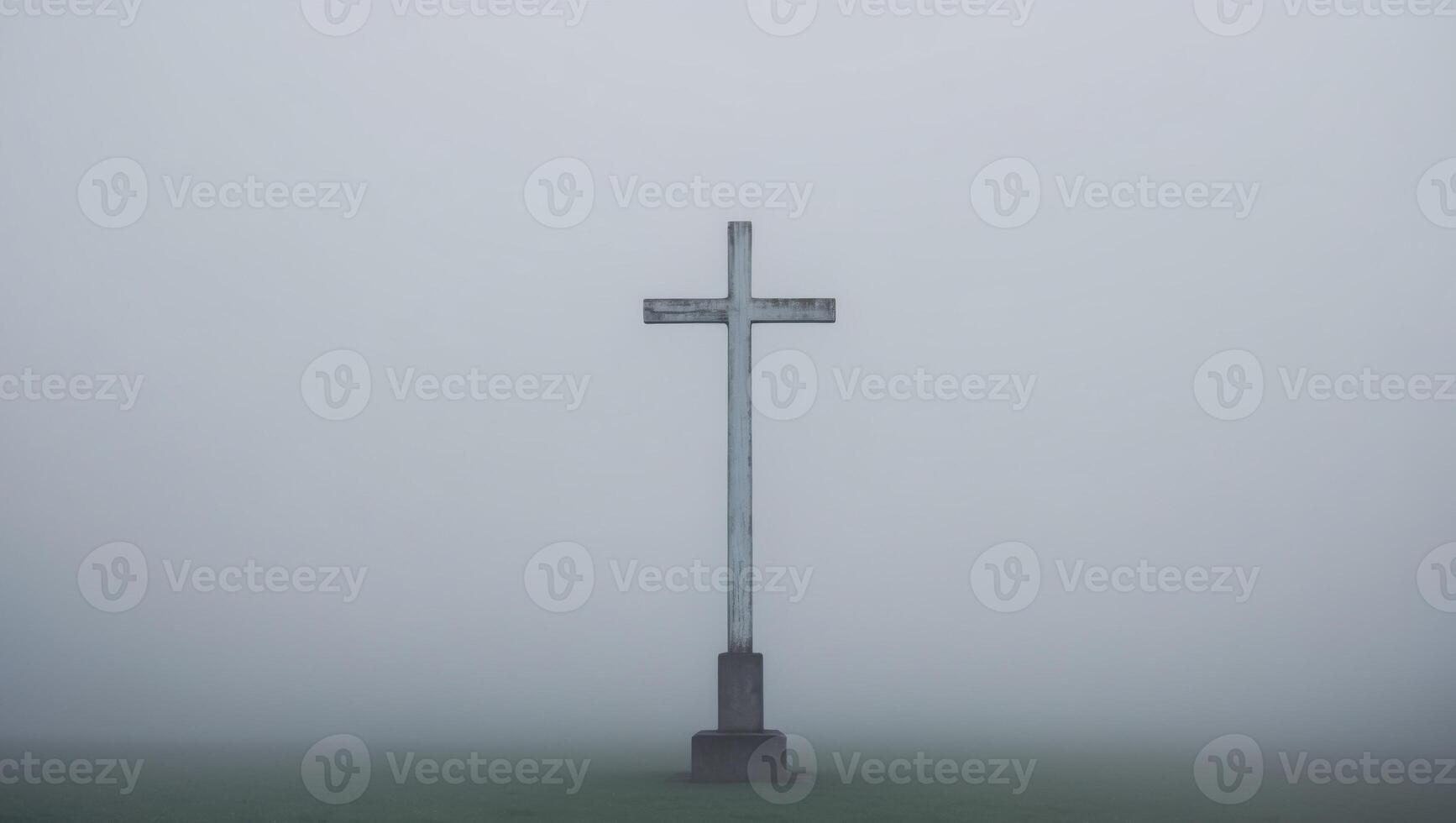 A cross stands alone in the fog on a hill photo
