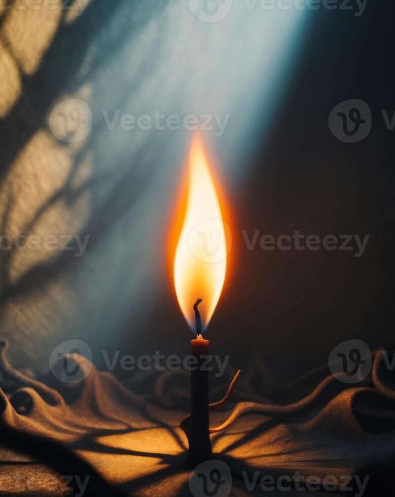 A burning candle is shown in the dark photo