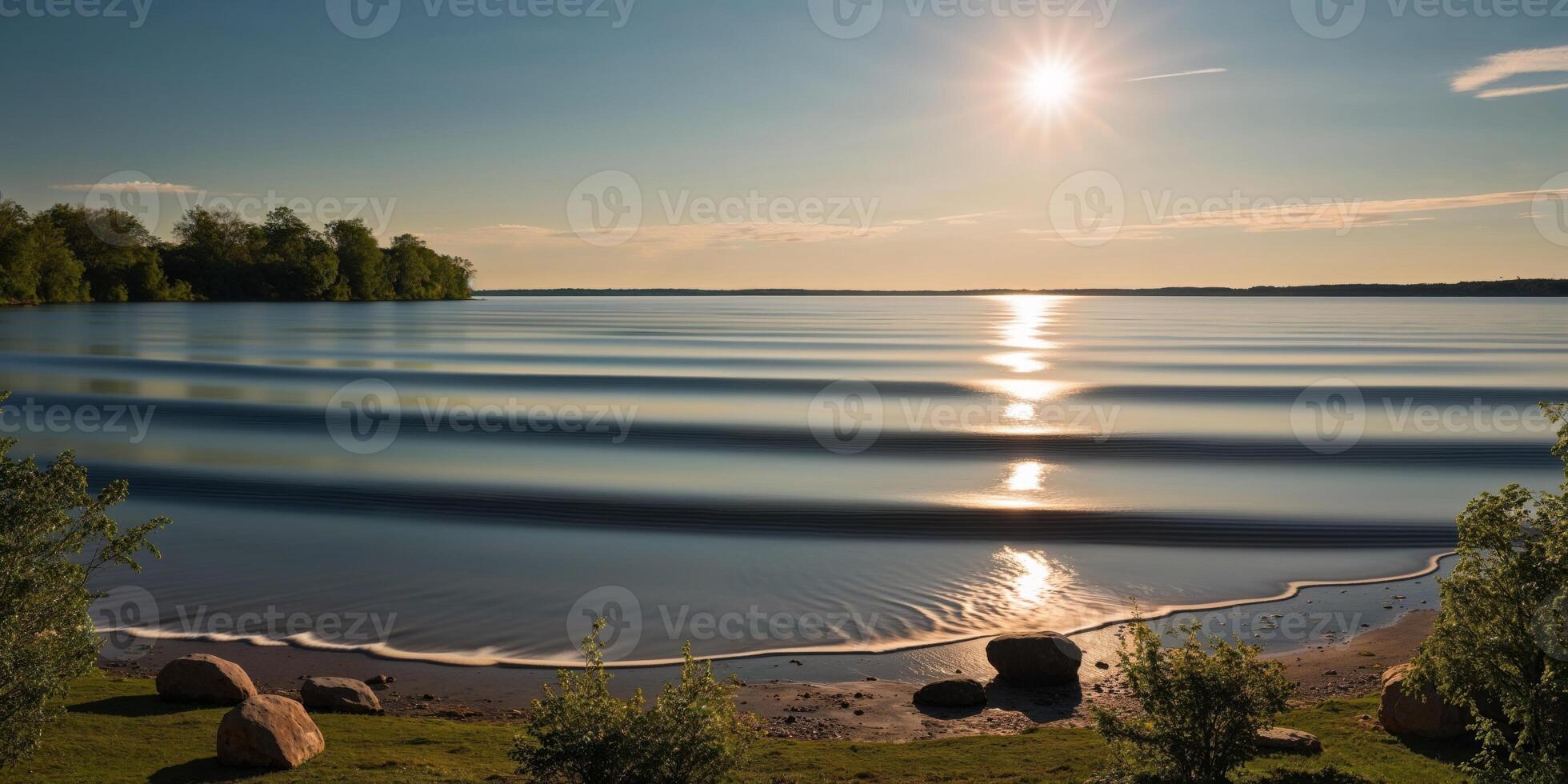 The sun shines over a lake and the water is calm photo
