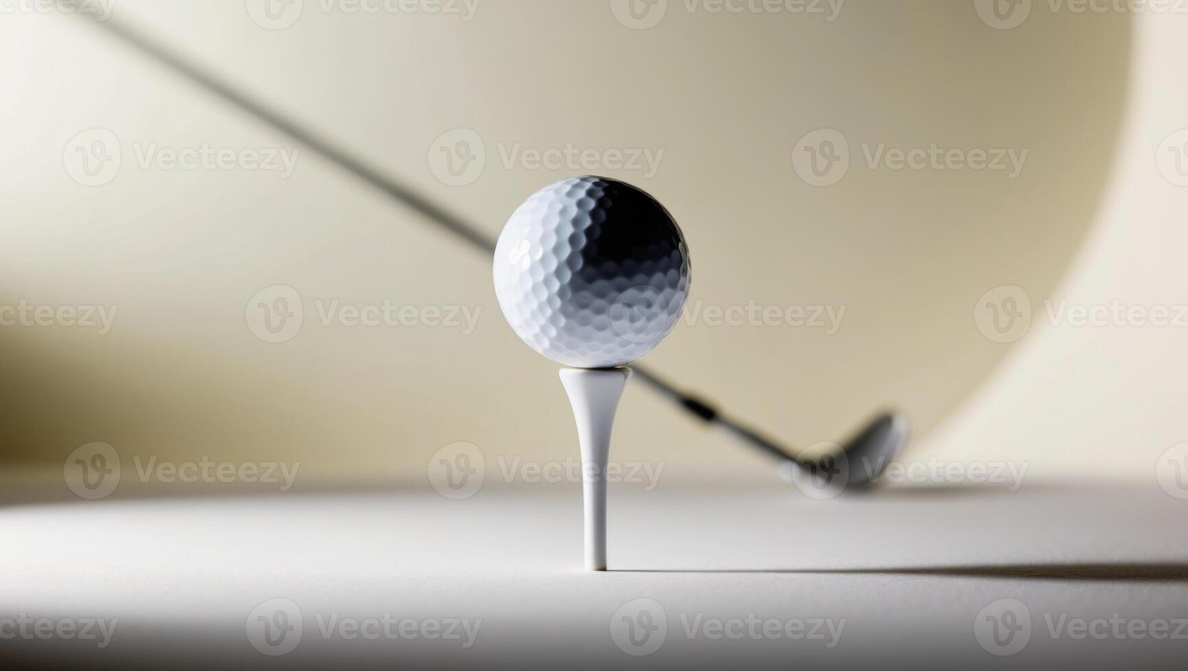 A golf ball on a tee with a golf club photo