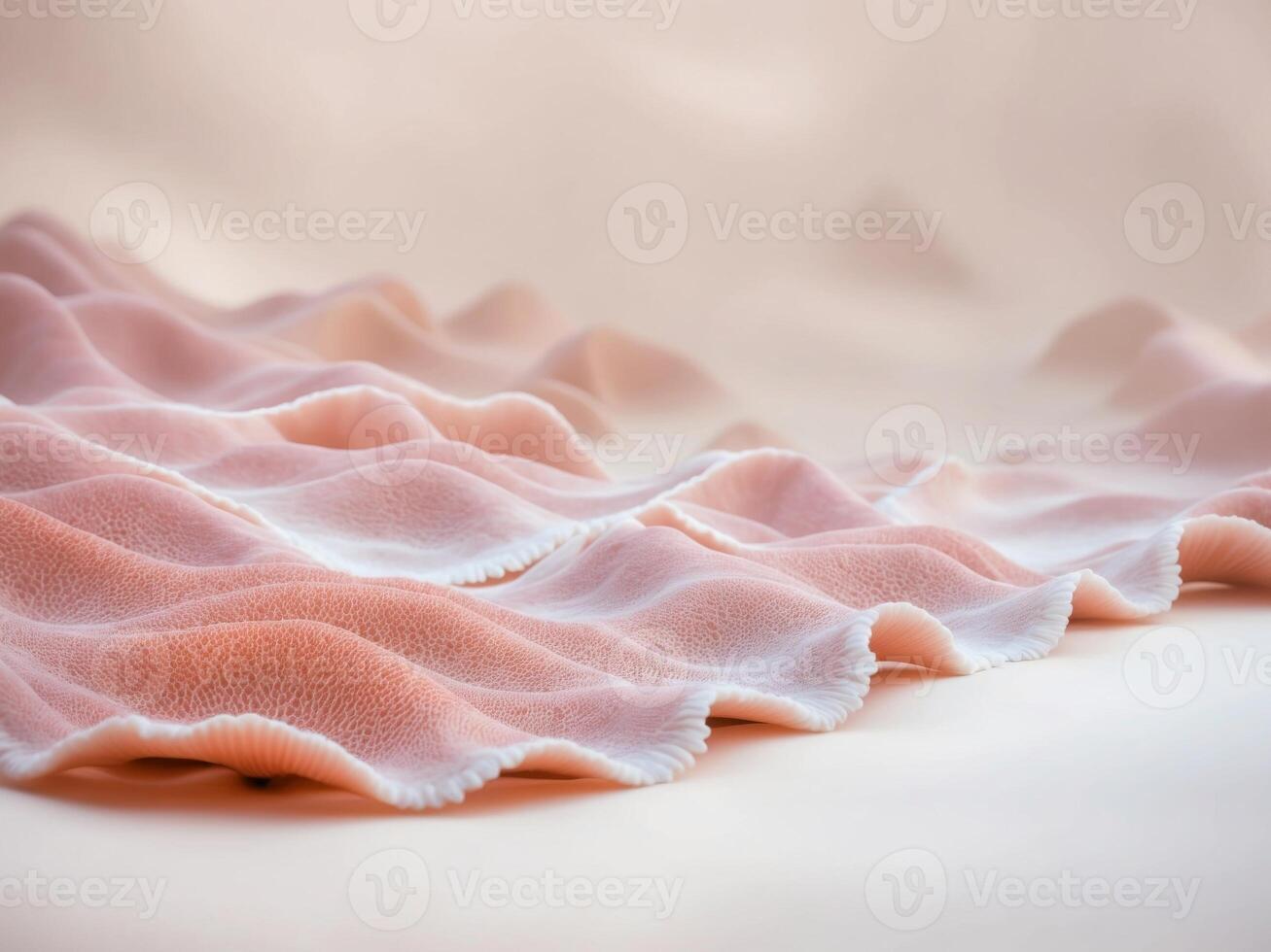 A pink and white fabric is laying on top of a white surface photo