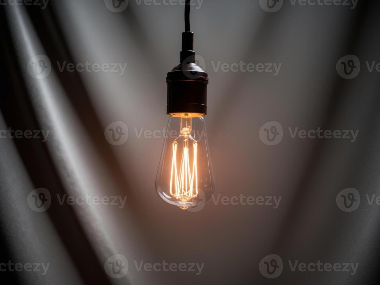 A light bulb is shown in front of a dark background photo