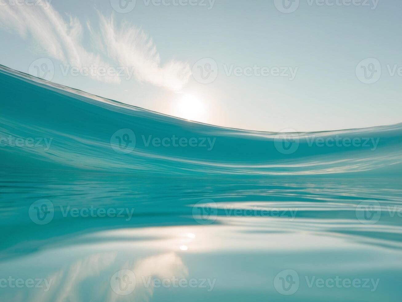 A wave in the ocean with a sun in the background photo