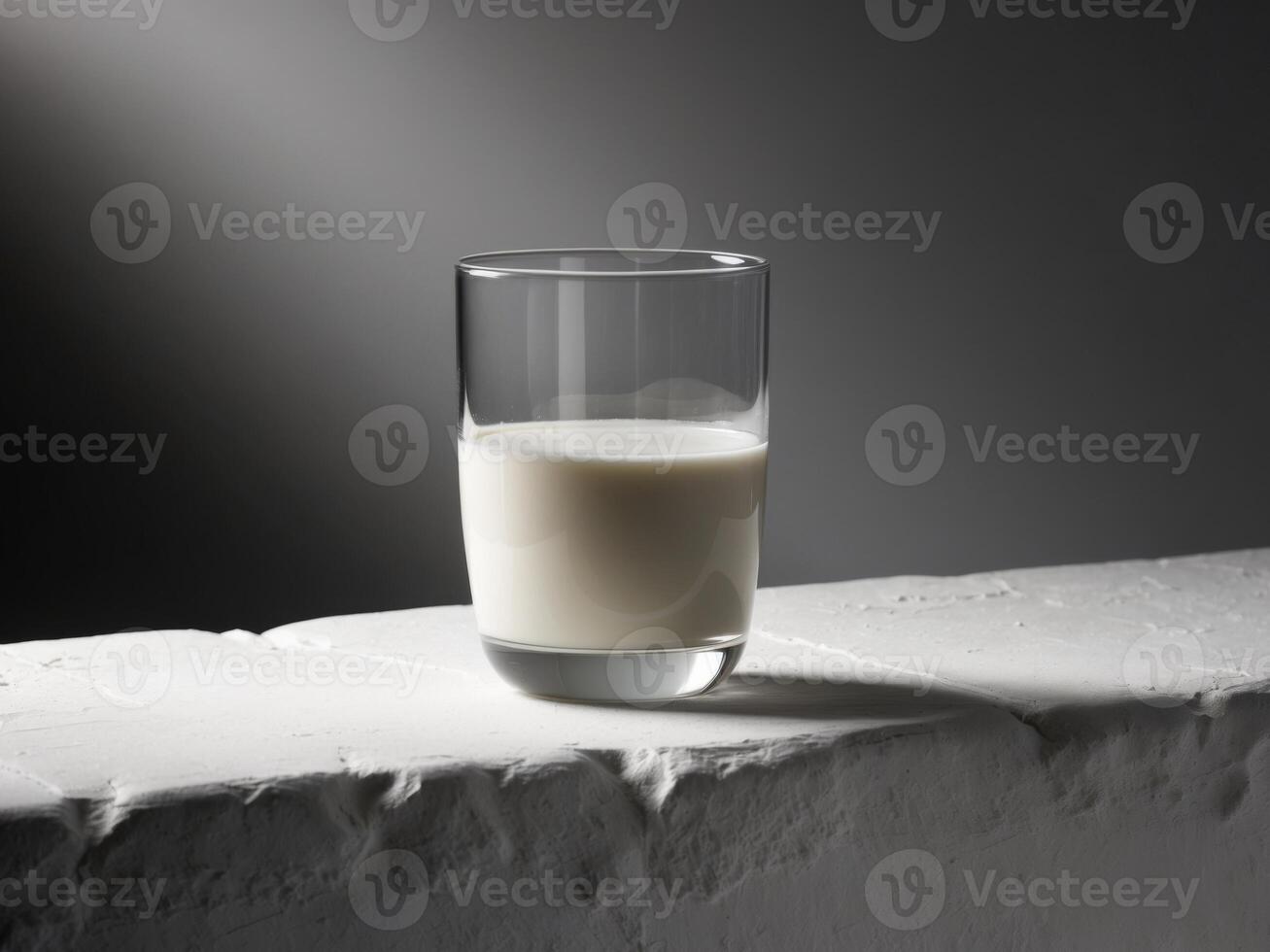 A glass of milk sitting on a stone wall photo