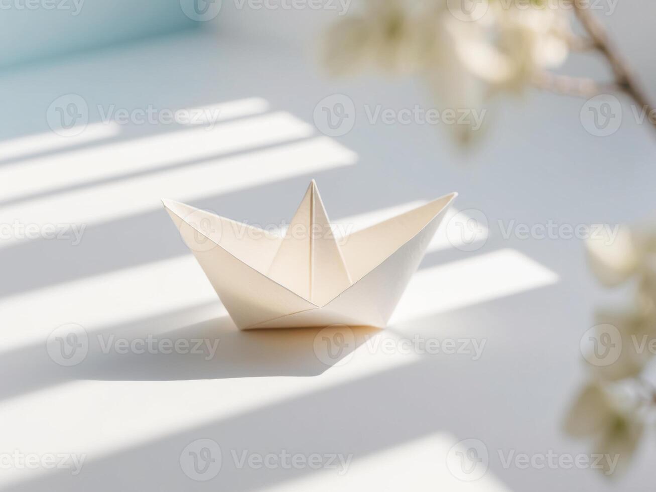 A paper boat sitting on a table with sunlight photo