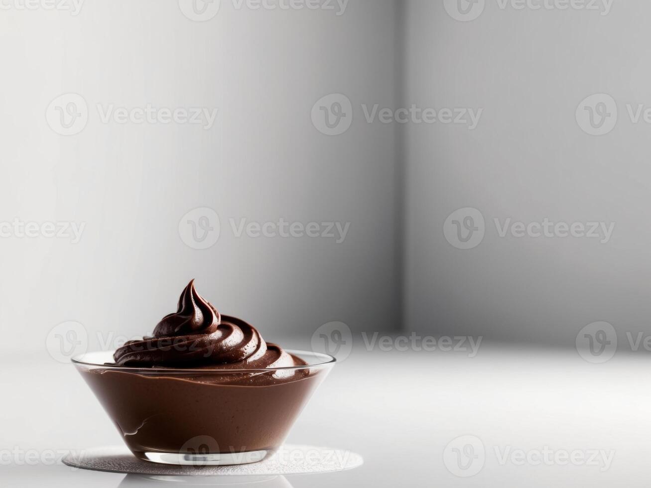 Chocolate pudding in a glass bowl on a white table photo