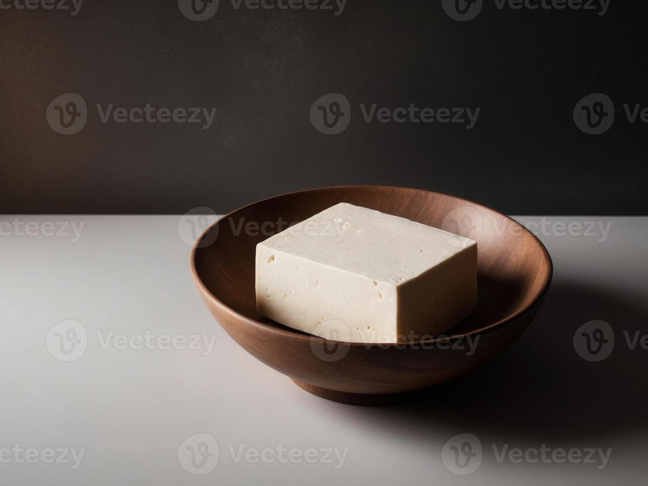 A wooden bowl filled with tofu on a table photo