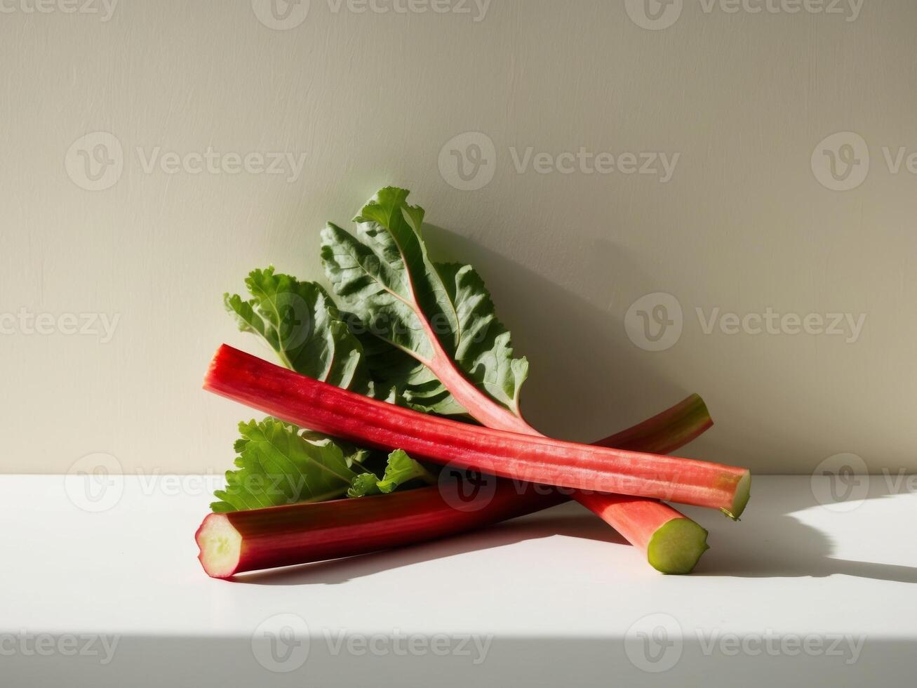 A bunch of red rhubarb on a white surface photo