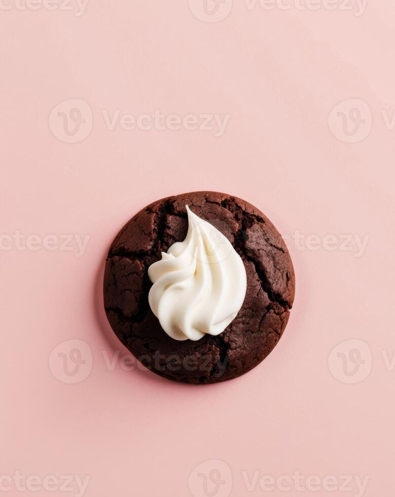 Chocolate cookie with whipped cream on pink background photo