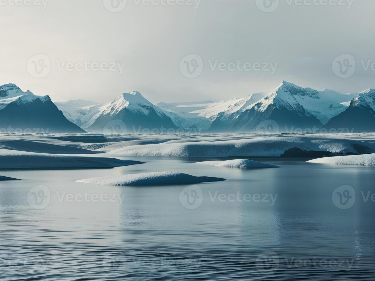 A large body of water with snow covered mountains photo