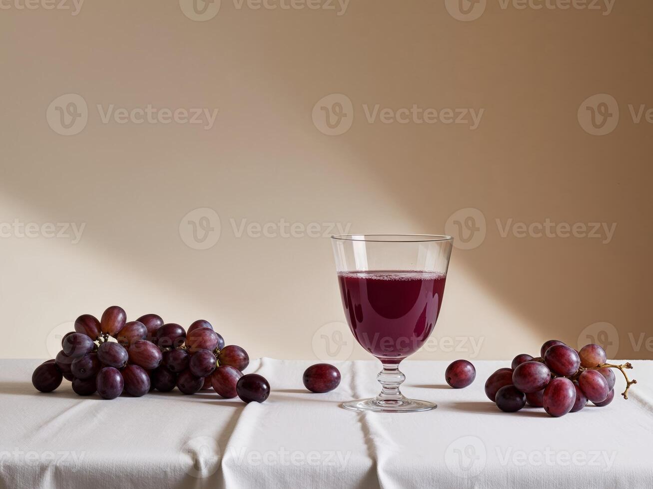 A glass of red wine and grapes on a table photo