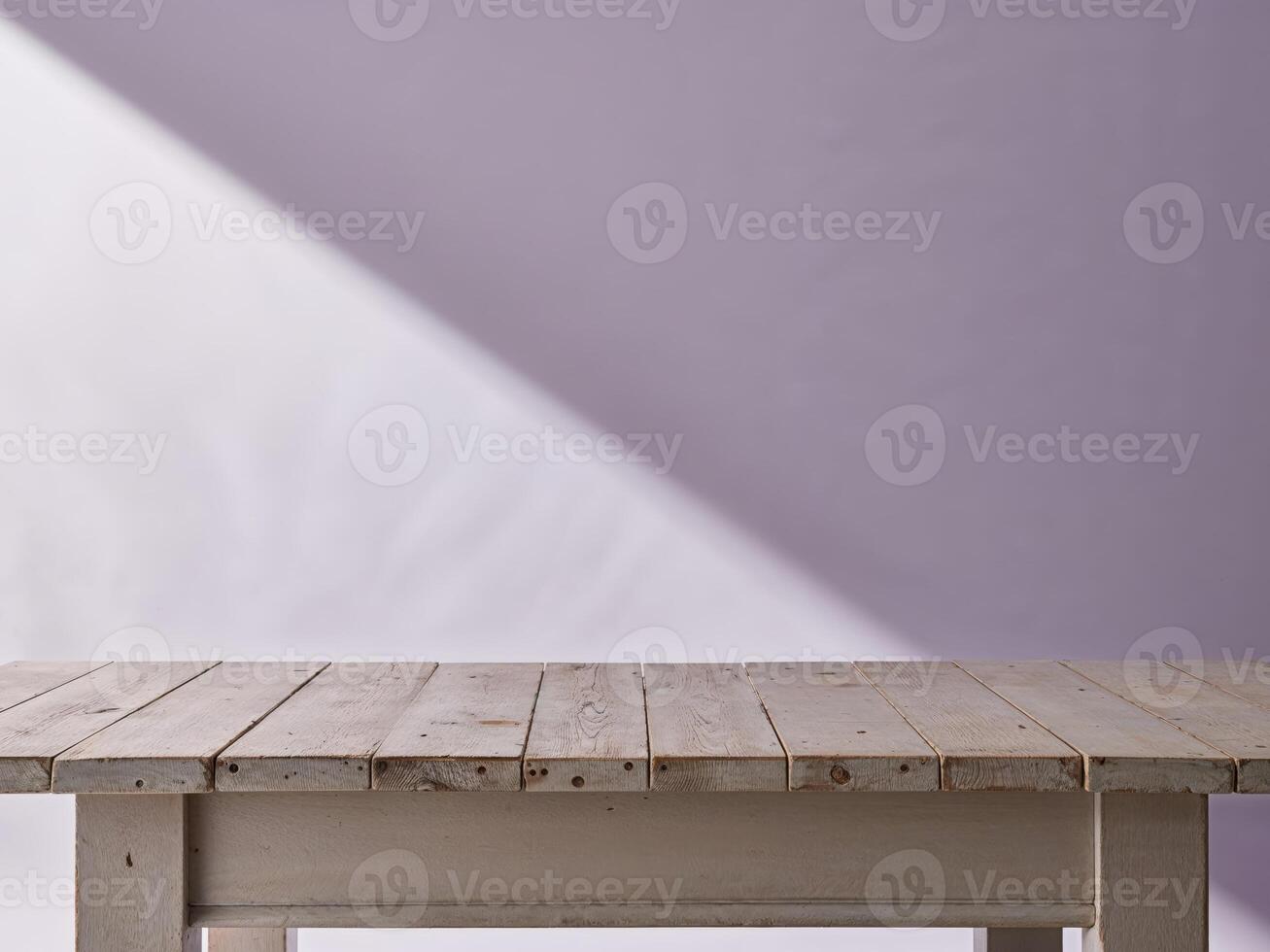 A wooden table with a purple wall behind it photo