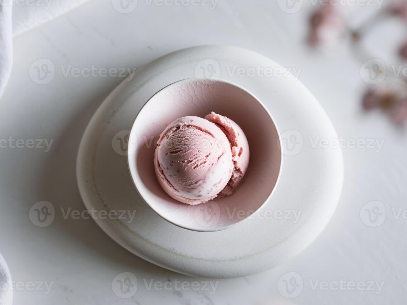 A bowl of ice cream sits on a white surface photo