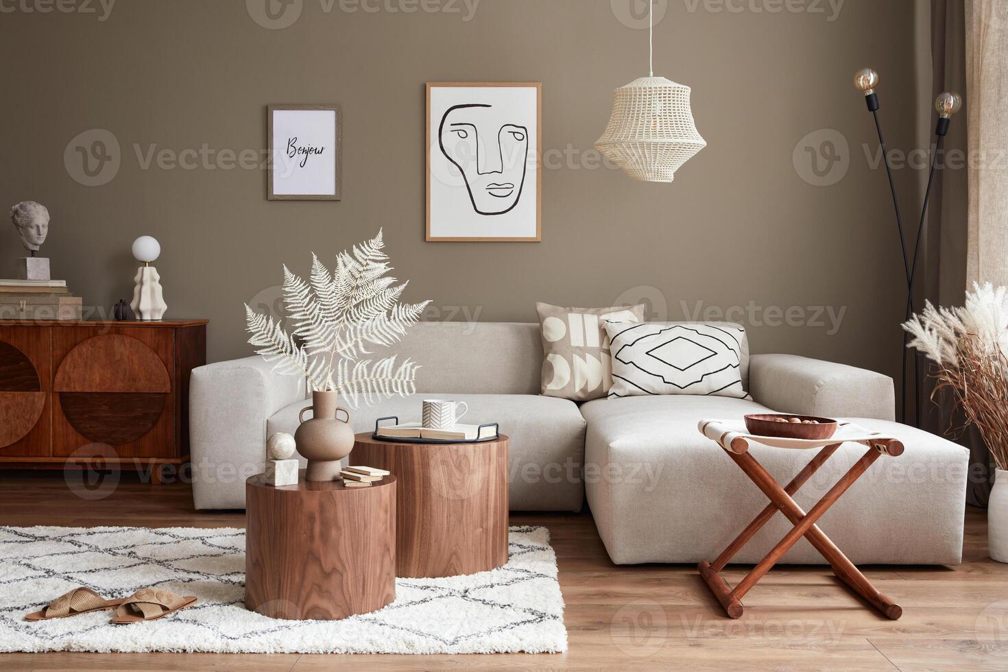 Interior design of stylish living room with neutral sofa, furniture, mock up poster farmes, dried flowers in vase, coffee tables, decoration and elegant personal accessories in home decor. photo
