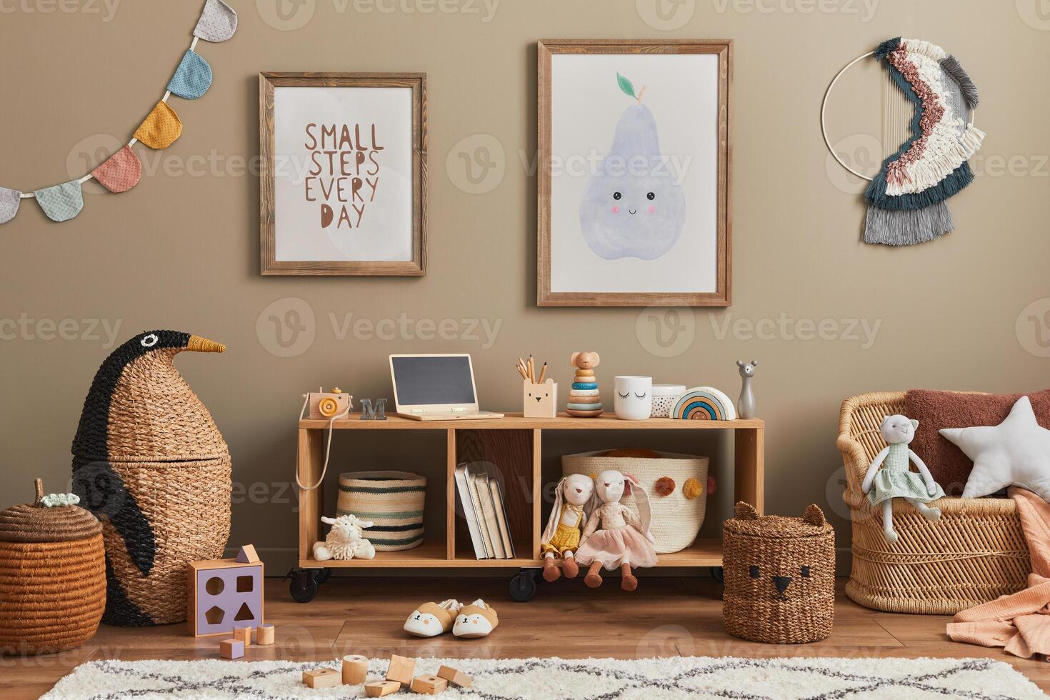 Stylish scandinavian kid room interior with toys, teddy bear, plush animal toys, sofa, furniture, decoration and child accessories. Brown wooden mock up poster frames on the wall. photo