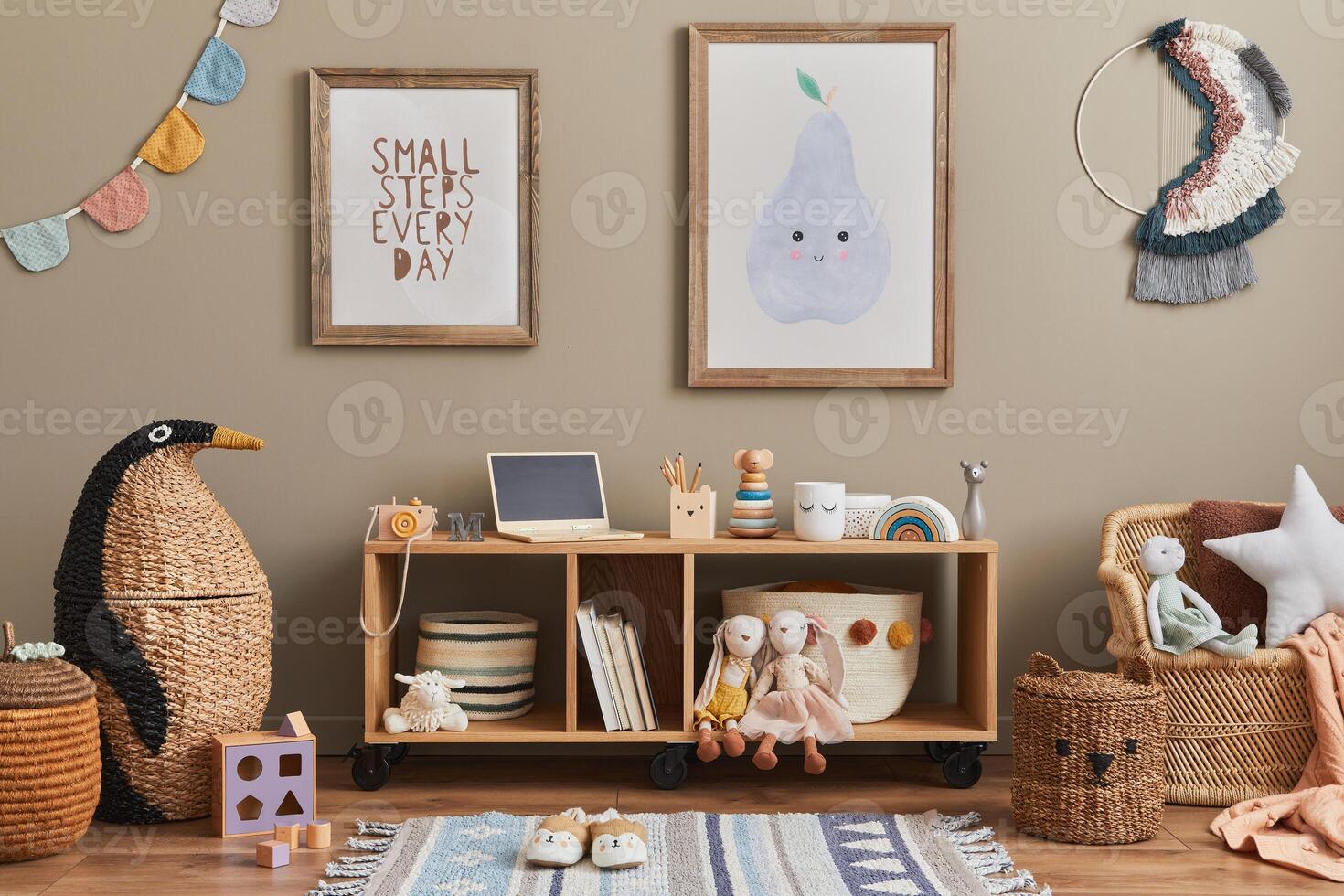 Stylish scandinavian kid room interior with toys, teddy bear, plush toys, mint armchair, furniture, decoration and child accessories. Brown wooden mock up poster frames on the wall. photo