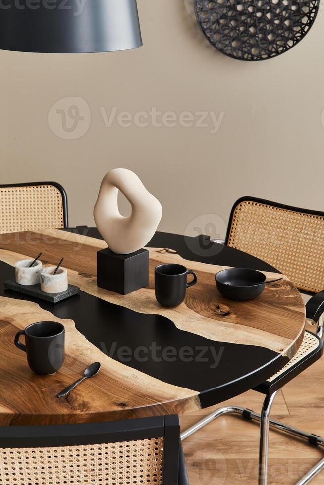 Minimalist composition on the design wooden and epoxy table with black teapot, cups and spoon. Modern dining room interior. photo