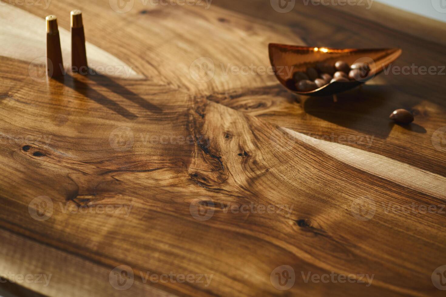 Interior design of stylish dining room interior with family wooden table, plate with nuts and salt and pepper shakers. Detalis. Table texture. Template. photo