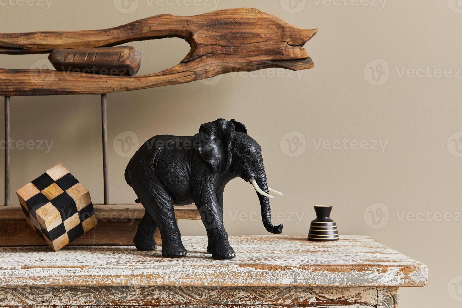 Stylish composition at moroccan interior with wooden shlef, cube, design elephant figure and decoration in modern home decor. photo