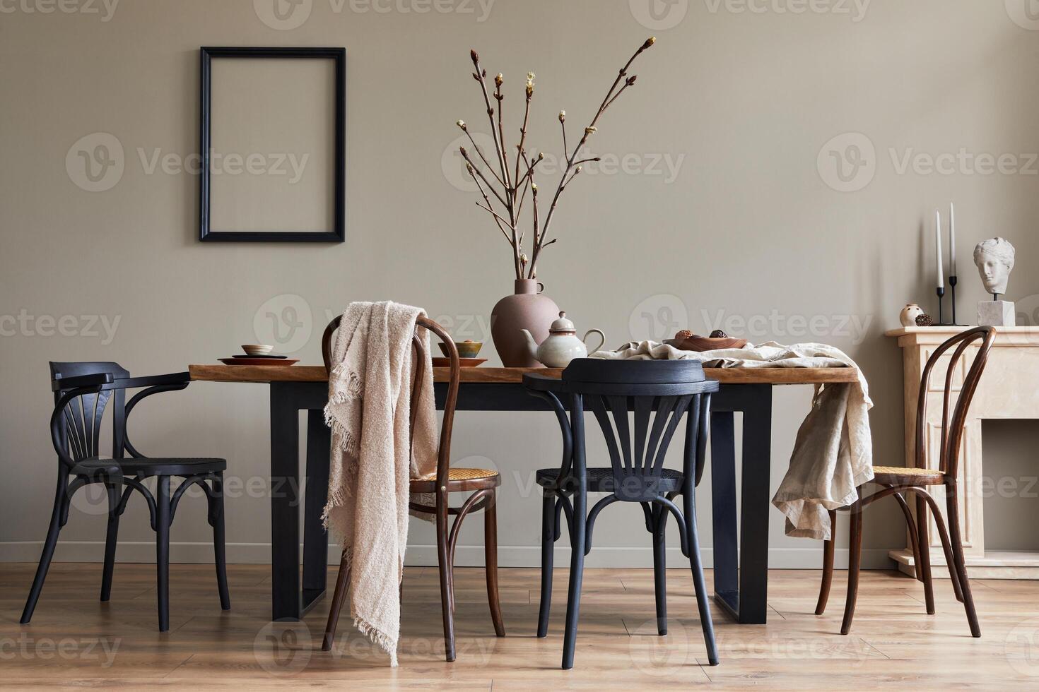 Stylish rustic interior of dining room with walnut wooden table, chairs, decoration, fireplace, dried flower, candlestick mock up picture frame and carpet in minimalist home decor. Template. photo