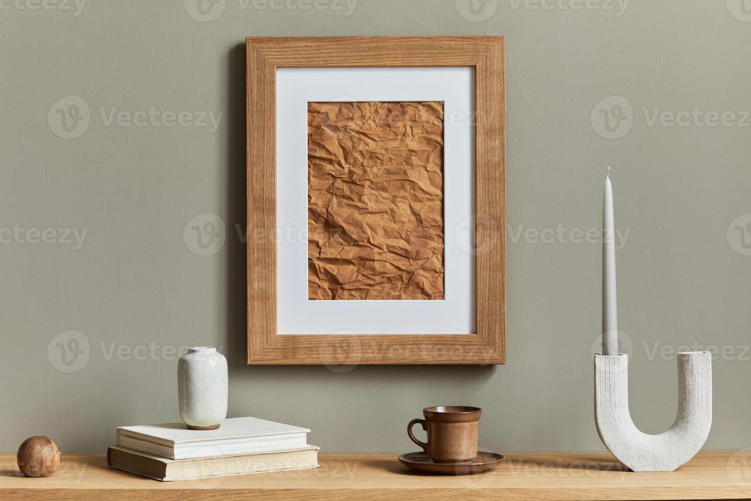 Minimalist composition on wooden shelf with brown mock up poster frame, candle stick, book, cup of coffee and elegant personal accessories in home decor. Template photo
