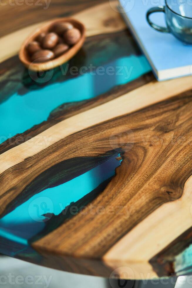 Close up of epoxy wooden coffee table with glass, nuts and a book. Details. Texture. photo