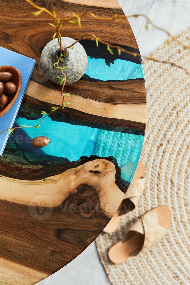 Close up of epoxy wooden coffee table with glass and book. Details. Texture. photo