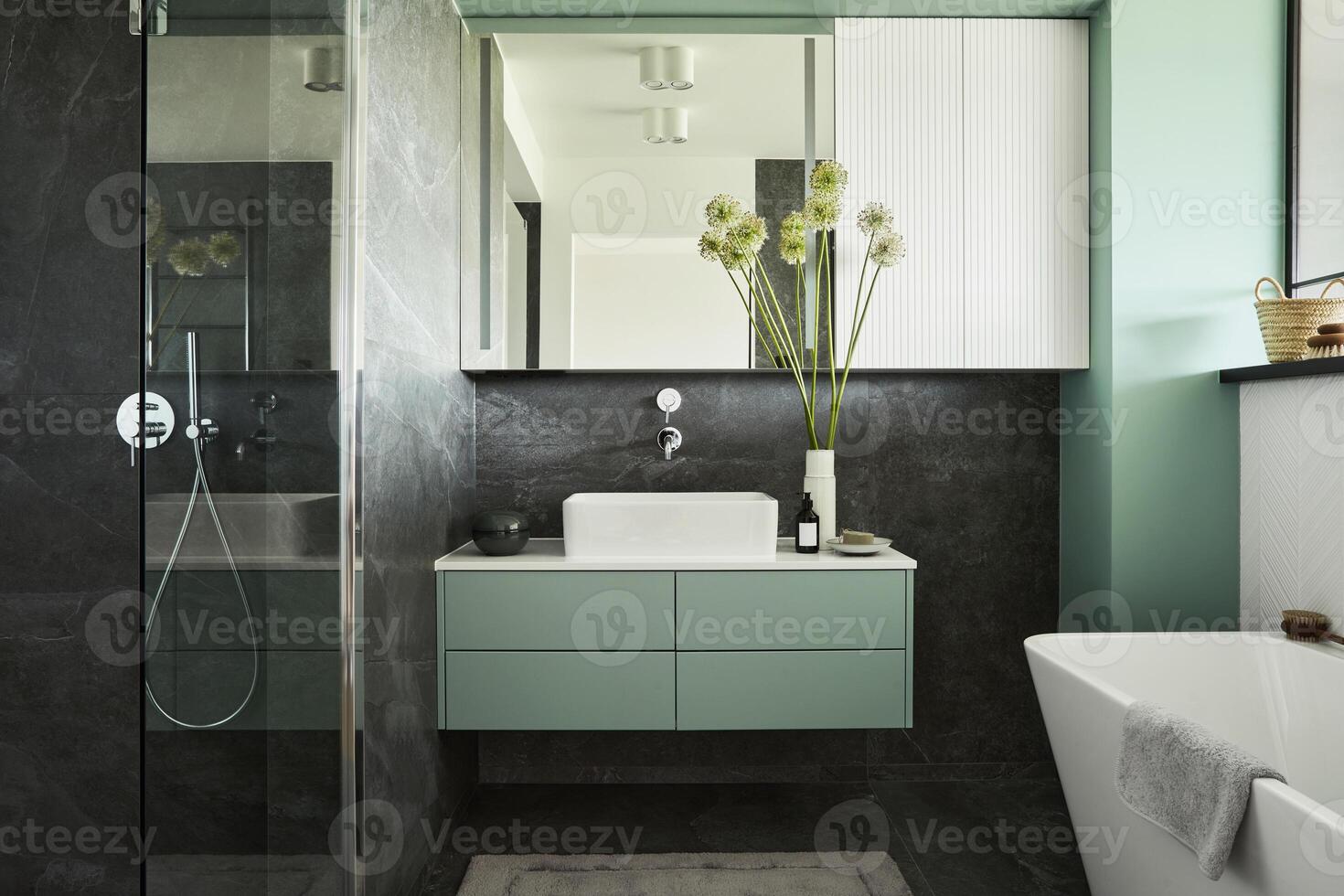 Stylish and creative minimalistic small bathroom interior design with marble walls with green panels, plants and beautiful bathroom accessories. Minimalistic concept. photo