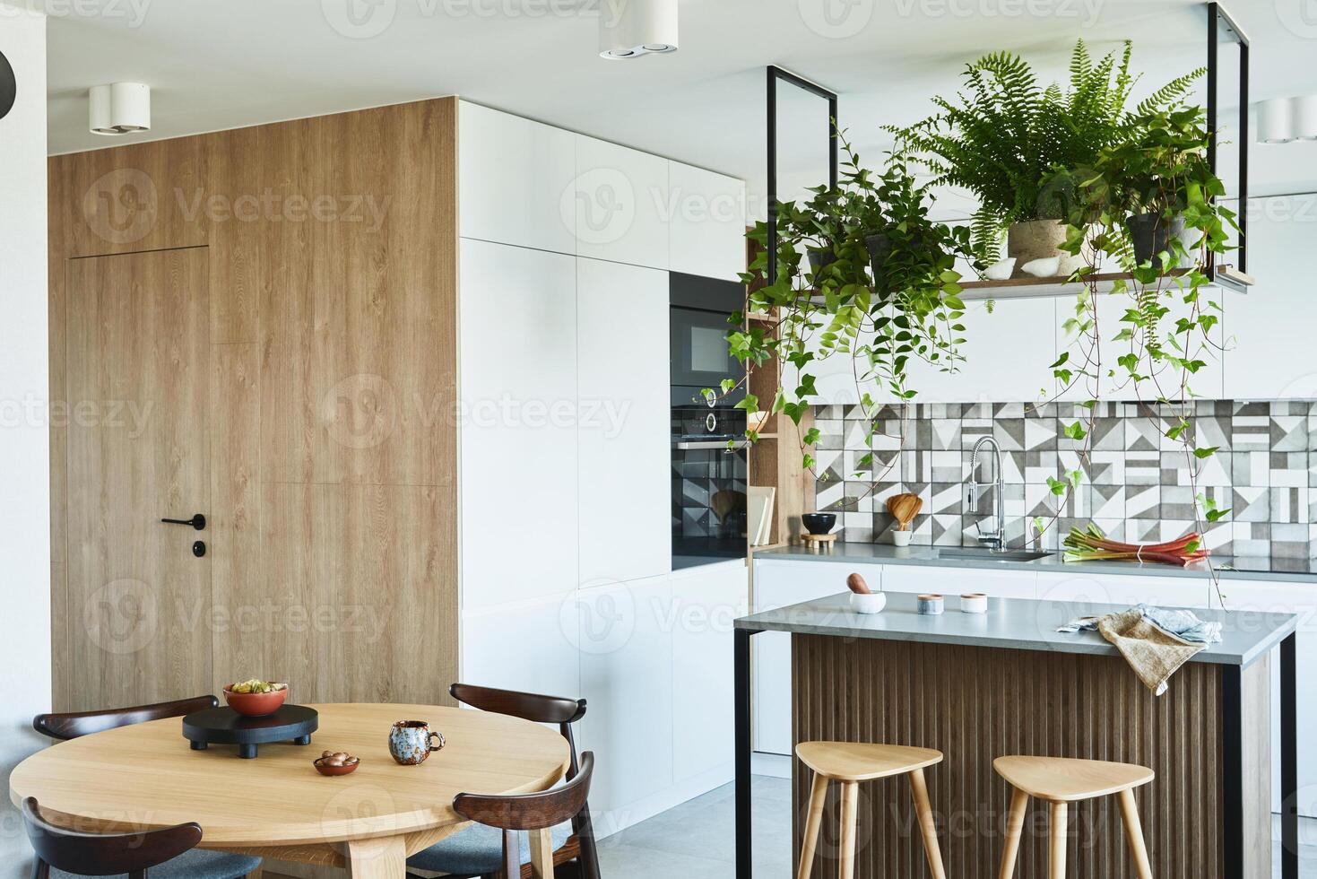 Stylish kitchen interior design with dining space. Workspace with kitchen accessories on the back ground. Creative walls with wooden pannels. Minimalistic style photo
