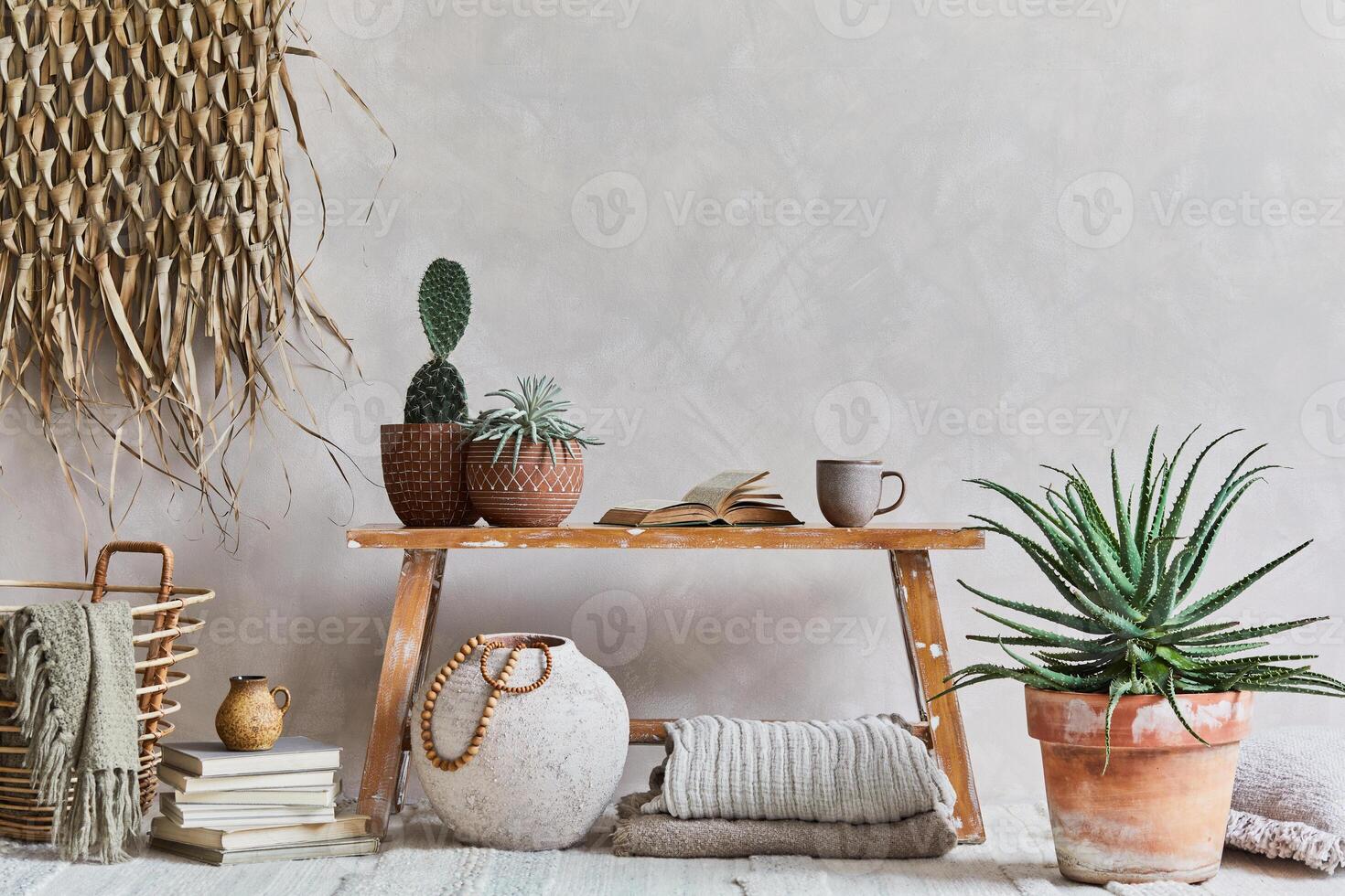 Stylish composition of living room interior with copy space, bench in retro style, clay vase, crockery, straw wall decoration and textiles. Rustic inspiration. Summer vibes. Beige wall. Template. photo