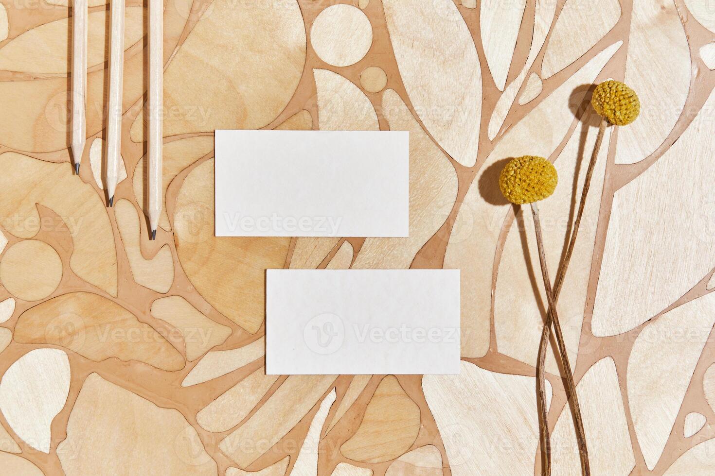 Stylish flat lay creative composition with mock up visit cards, pencil, wood, natural materials, dry plants and personal accessories. Neutral colors, top view, template. photo