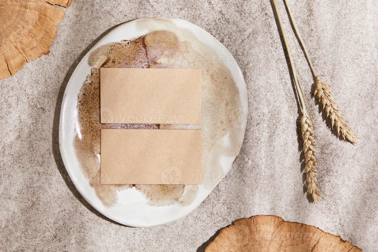 Flat lay of creative composition with mock up visit cards, rocks, wood, natural materials, dry plants and personal accessories. Neutral colors, top view, template. photo