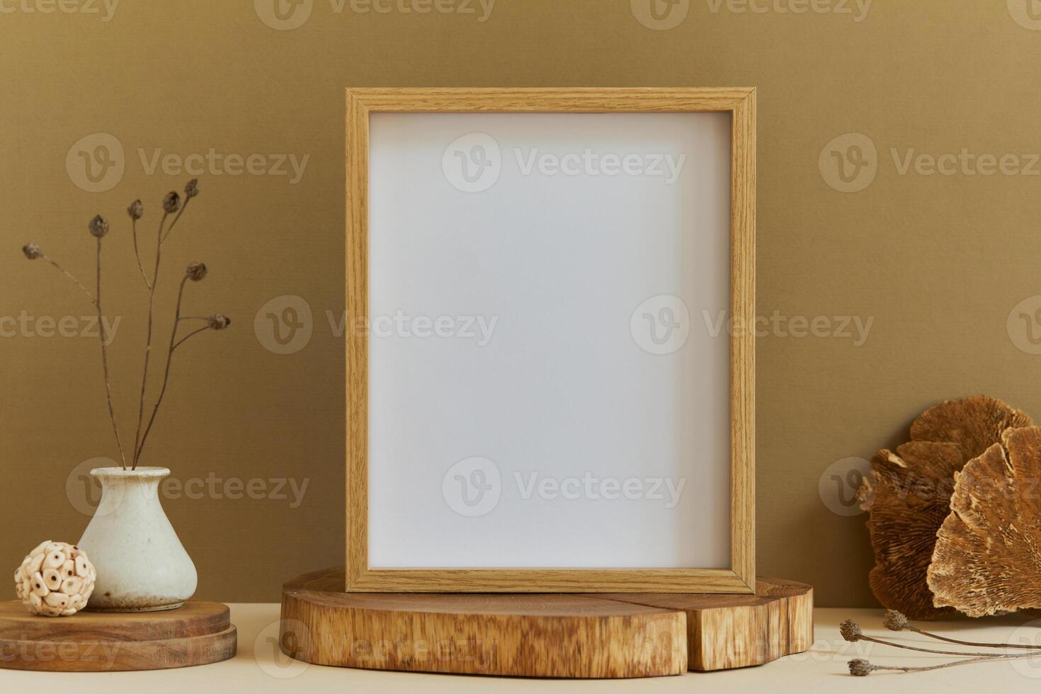 Stylish composition of minimalistic room interior design with mock up poster frame, natural materials as wood, dry plants and personal accessories. Neutral and yellow colors, template. photo