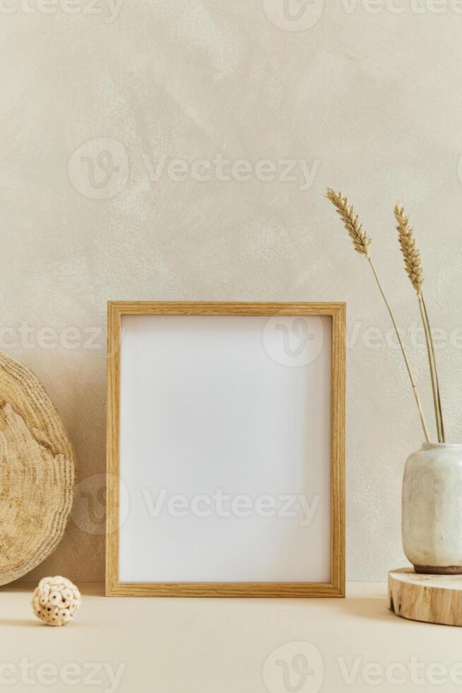 Stylish cozy minimalistic interior design composition with mock up poster frame, natural materials as wood and marbel and personal accessories. Neutral beige colors photo