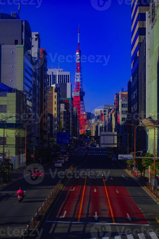 A traffic at the urban street behind Tokyo tower vertical shot photo