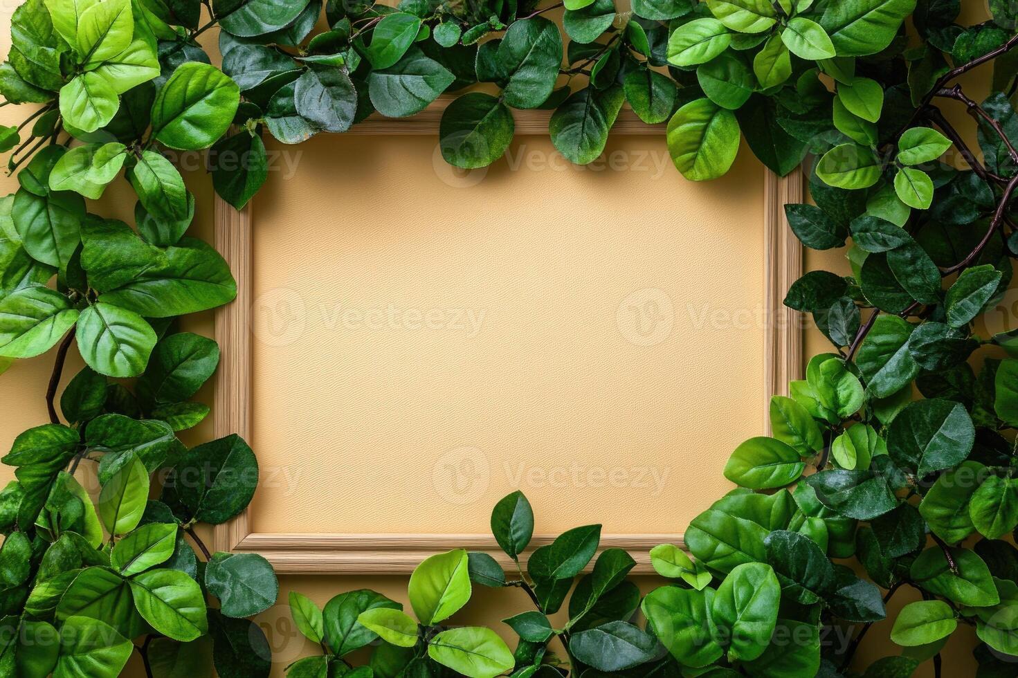 Wooden frame surrounded by green leaves on beige background photo