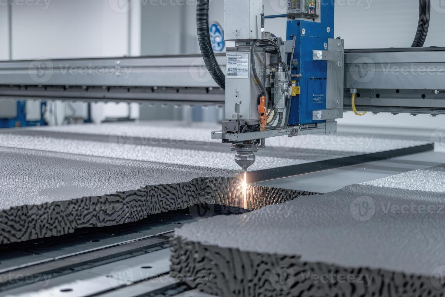 Laser cutting machine cutting foam material in a factory photo