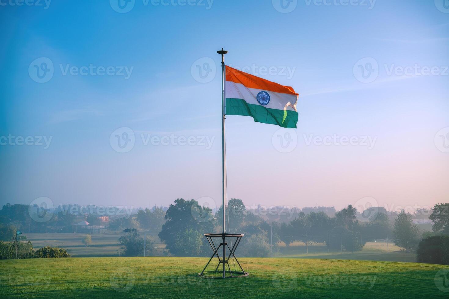 Indian flag waving in the wind on a clear morning overlooking green fields photo