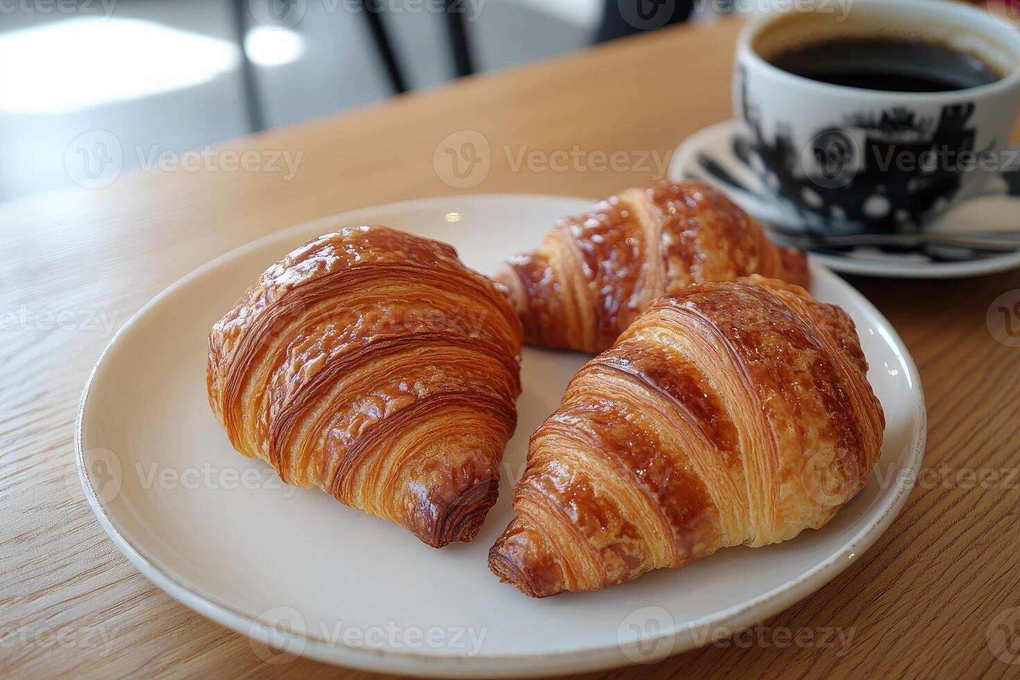 Delicious golden brown croissants resting on white plate with coffee enjoyed in cafe photo