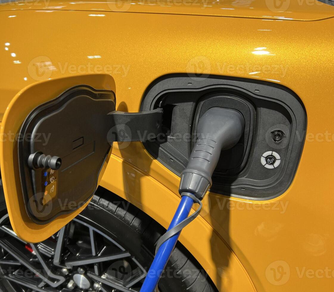 Electric vehicle charging at a public charging station in a city setting. New energy vehicles, eco-friendly alternative energy for cars. Electric cars are becoming more common and gaining popularity. photo