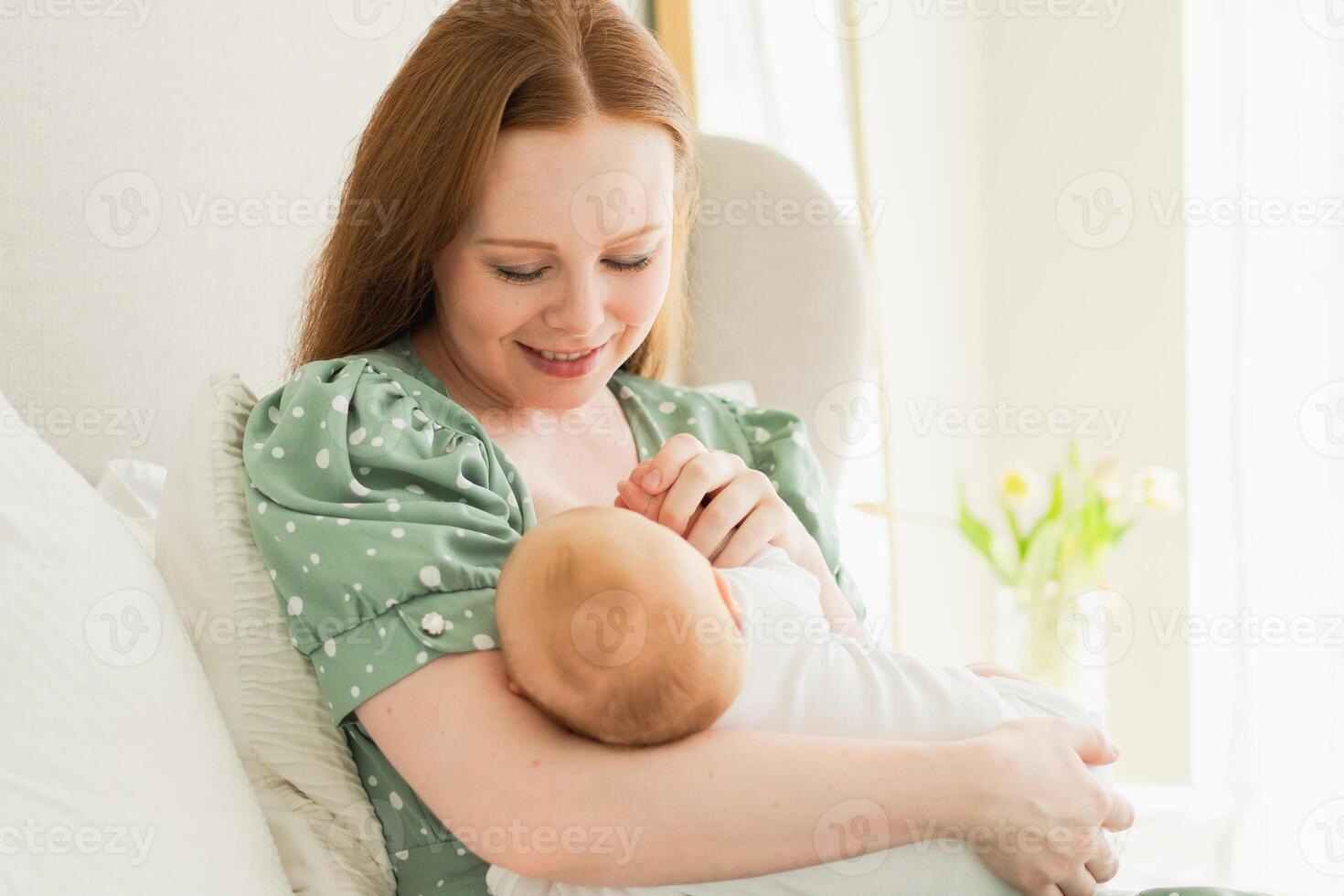 Happy family at home. Mother holding little toddler child daughter. Mom baby girl relax playing having fun together at home. Mother hugs baby with love care. Mom of breast feeding baby in living room photo
