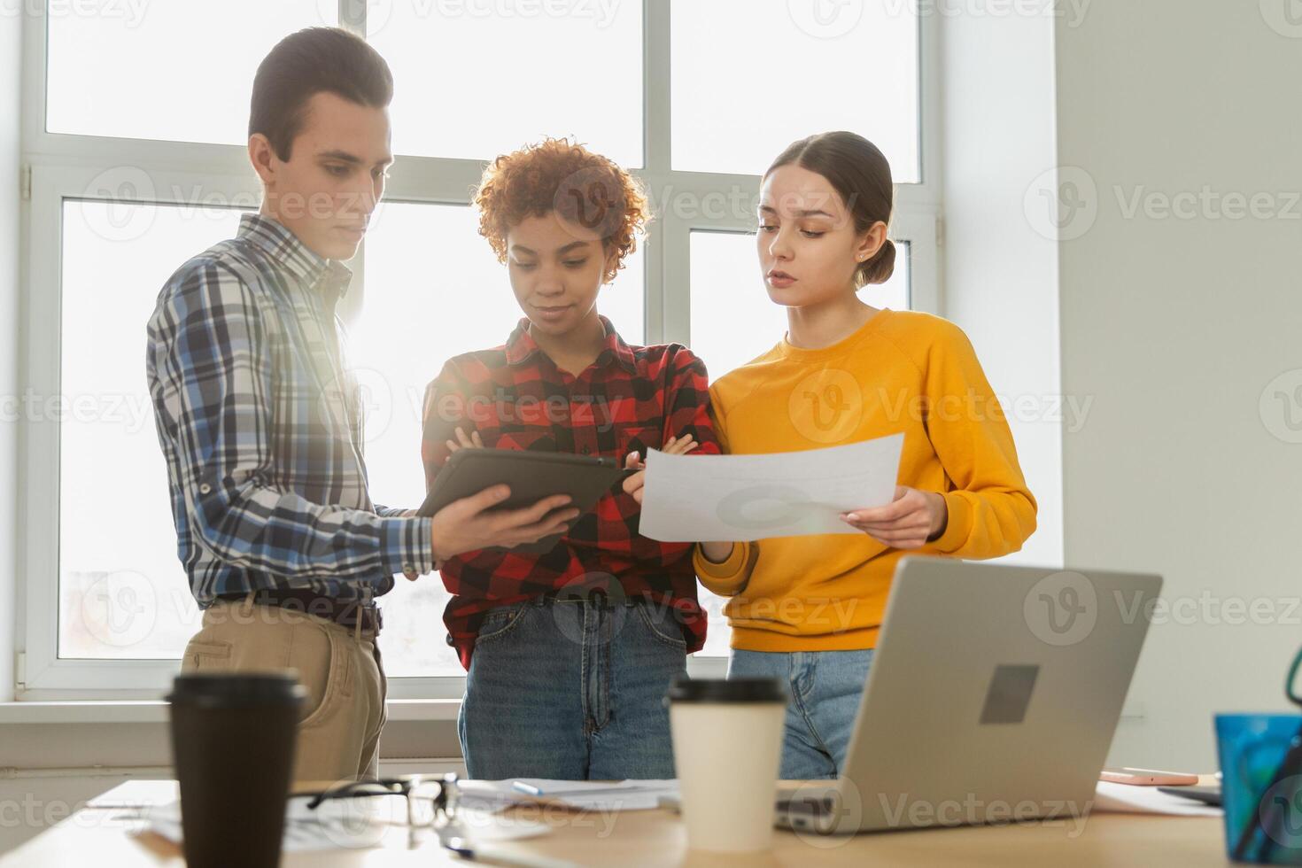 Teamwork brainstorm young professional team concept. Happy multiracial coworkers cooperating working together at office meeting. Diverse colleagues discussing project ideas editing documentation photo