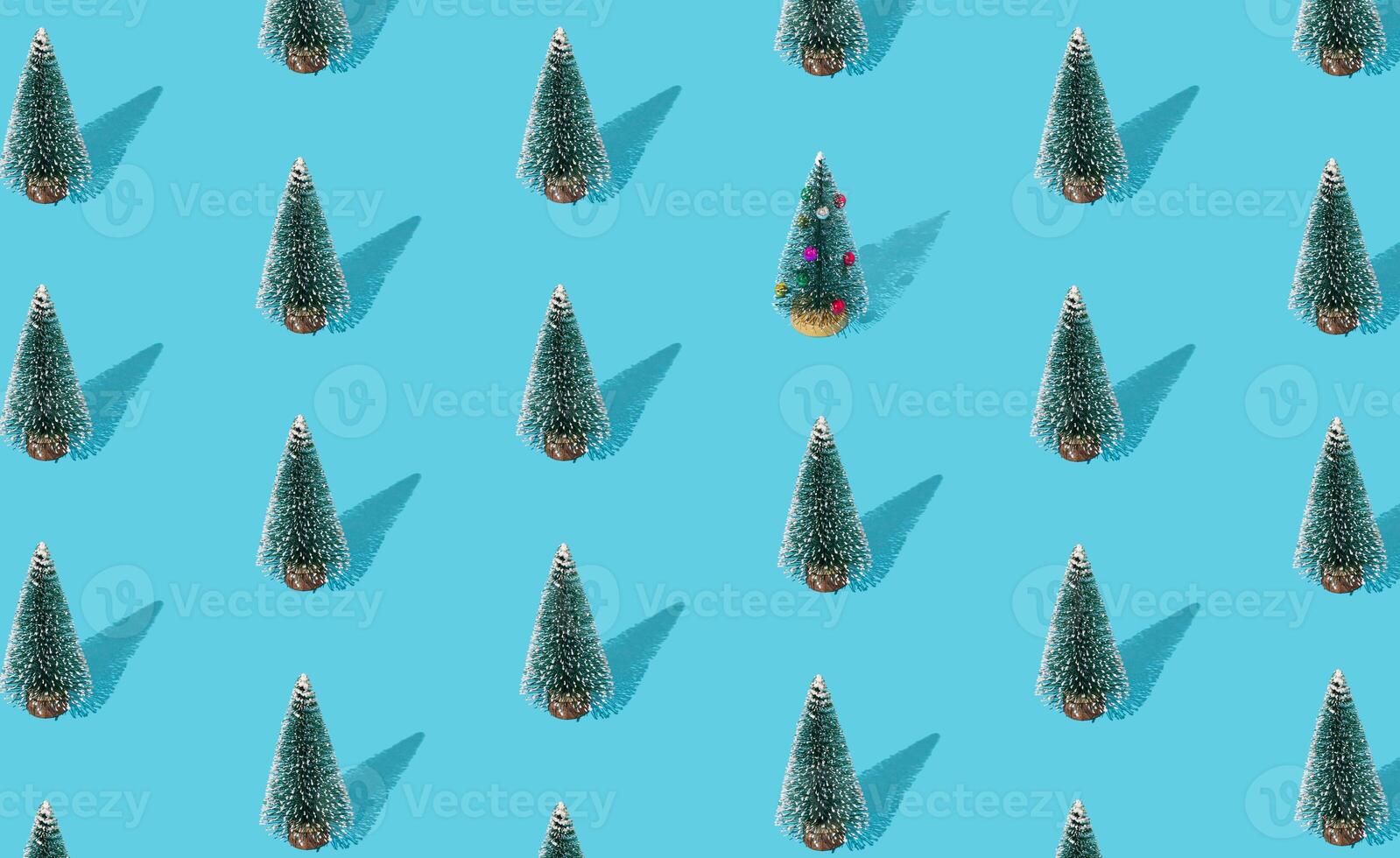 Christmas pattern composition made of green Xmas tree on blue background. Creative minimal Christmas and New Year concept. Festive winter holiday pattern backdrop. Christmas aesthetic background. photo