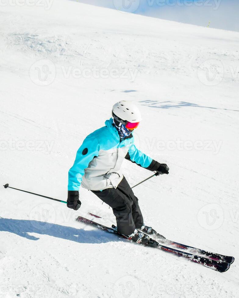 Expert skier on the slopes in Winter snowy mountains sunny day outdoors carve spray snow. Skills and professional skiing instructor photo