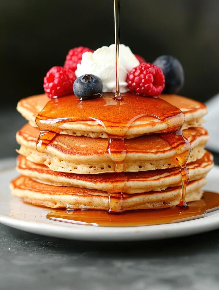 Delicious stack of pancakes with fresh berries and maple syrup photo