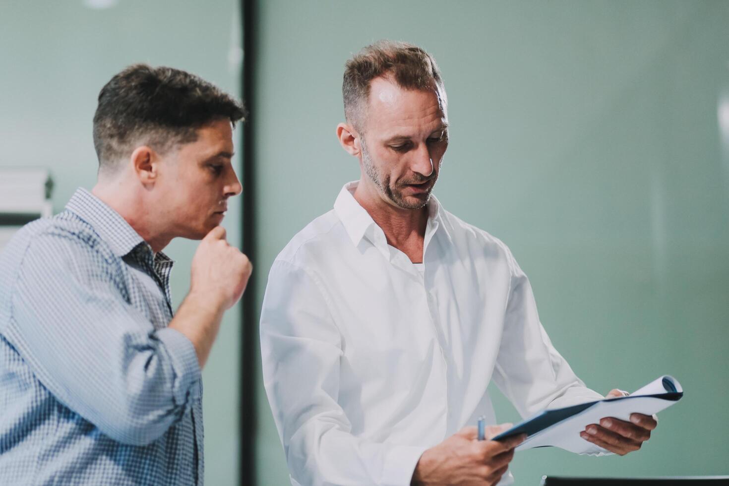 Two businessmen working together Analyze financial reports with charts and graphs while using the calculator to calculate budget, income, taxes, business growth. Startup business idea. photo